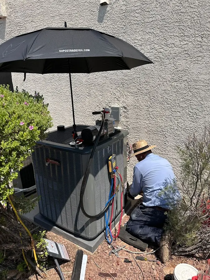 HVAC technician performing outdoor AC maintenance in Youngsville